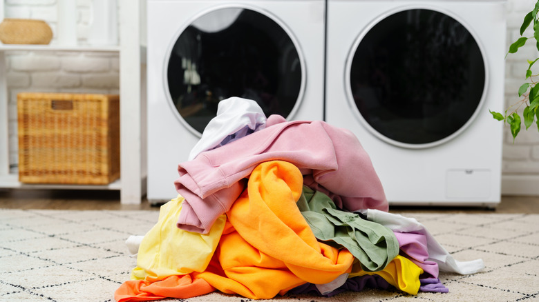 laundry pile with white and colorful clothes in laundry room