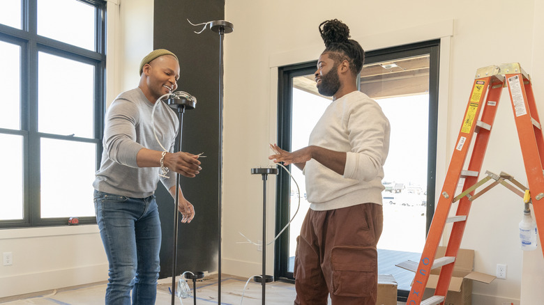 Michel Smith Boyd and Anthony Elle working with light fixtures