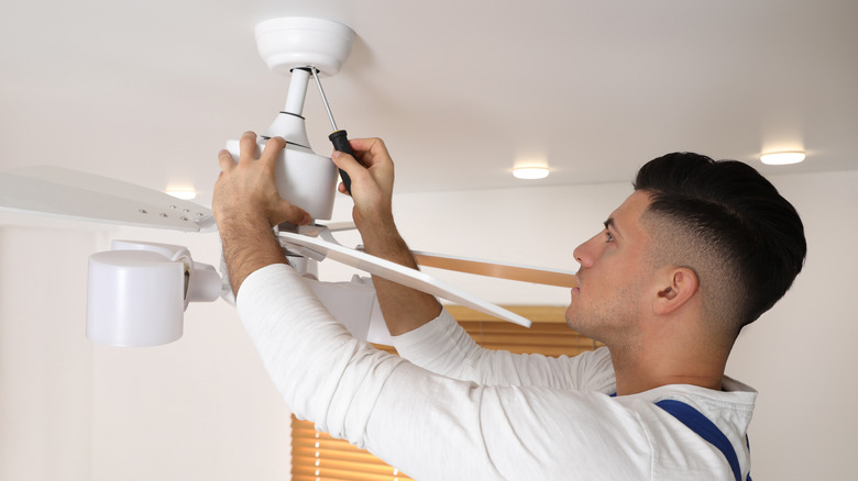 man installing ceiling fan