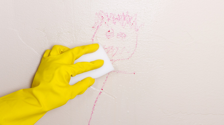 Magic eraser being used to get rid of crayon on a wall.