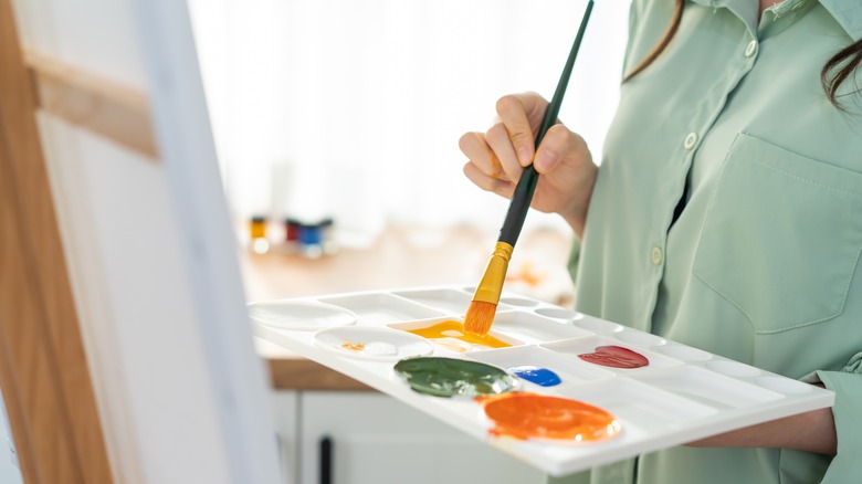 woman painting a canvas board