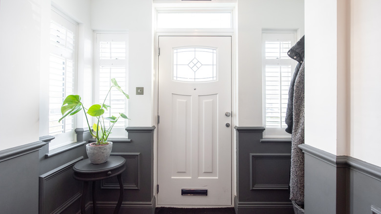 A white front door with windows and thin side windows.