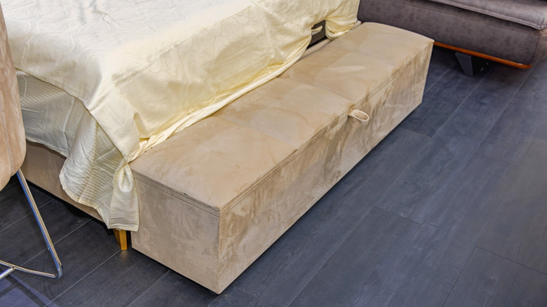 Tan storage bench at the end of bed