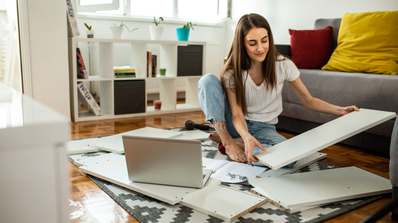 A woman prepares to build furniture in a living room