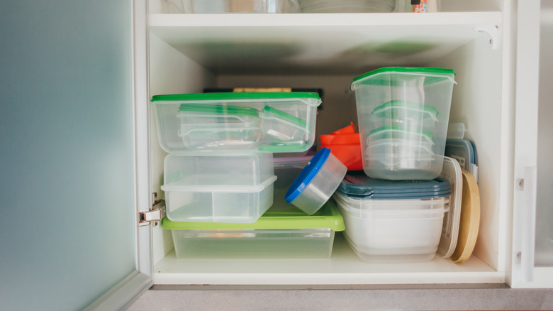 cluttered cabinet with food storage containers