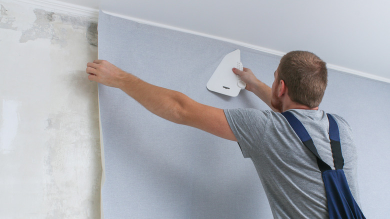 Man applying wallpaper