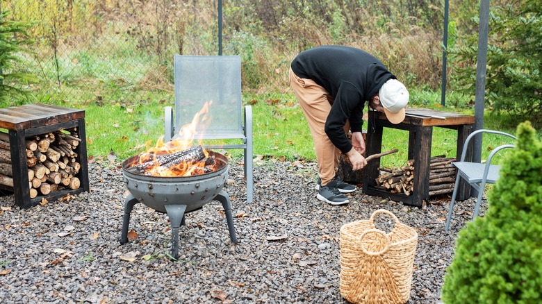 firepit and man stacking firewood