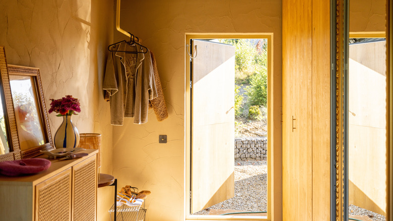 An entryway with a cabinet and coat rack