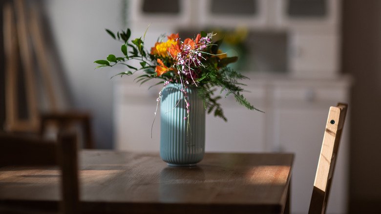 Blue vase with flowers on table