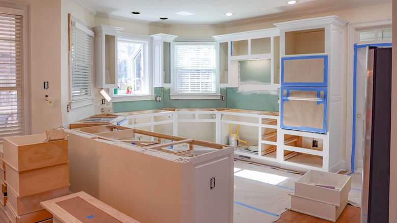 A kitchen has cabinets that are mid-installation