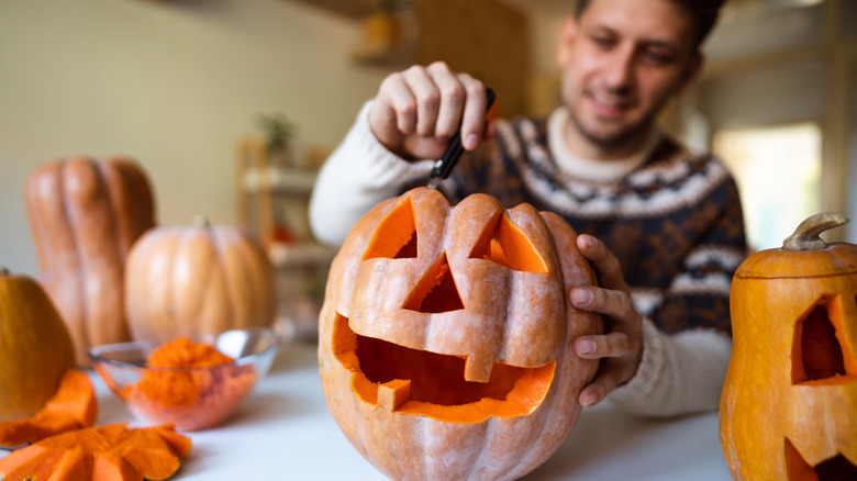 Man carving Jack-o-lantern