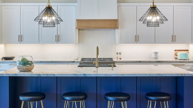 Contemporary kitchen with natural stone countertops and pops of blue