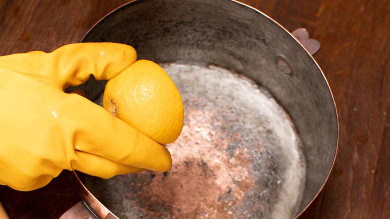 Holding lemon above copper pot