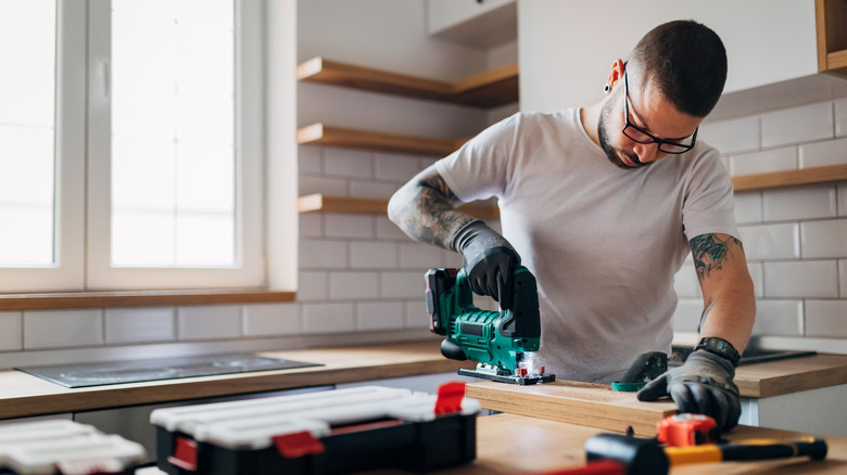 Man sawing in kitchen