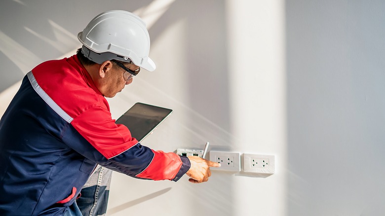 Man testing plug socket