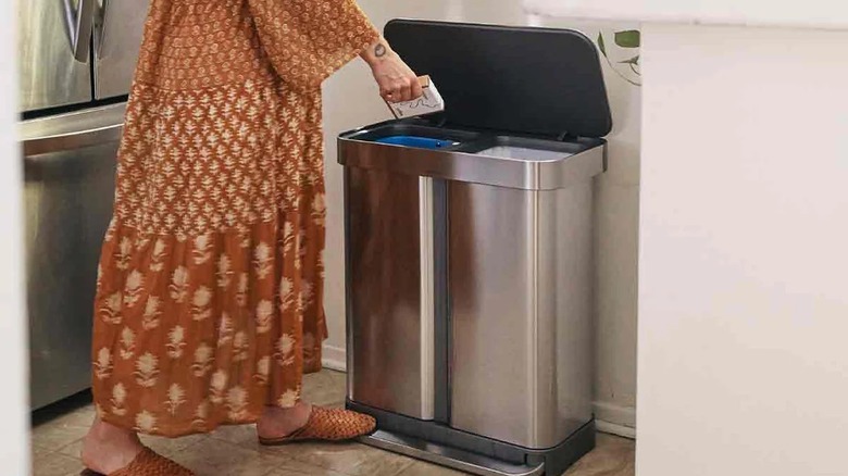 woman putting trash in bin