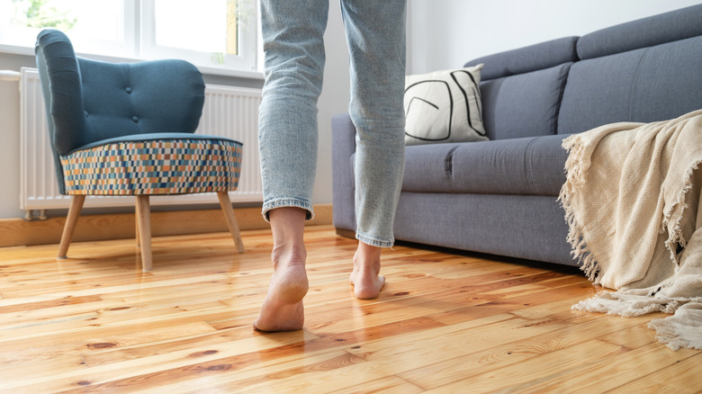 Person walking barefoot in a living room