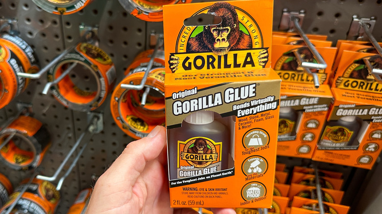 A person holding a bottle of Gorilla Glue in a store product display