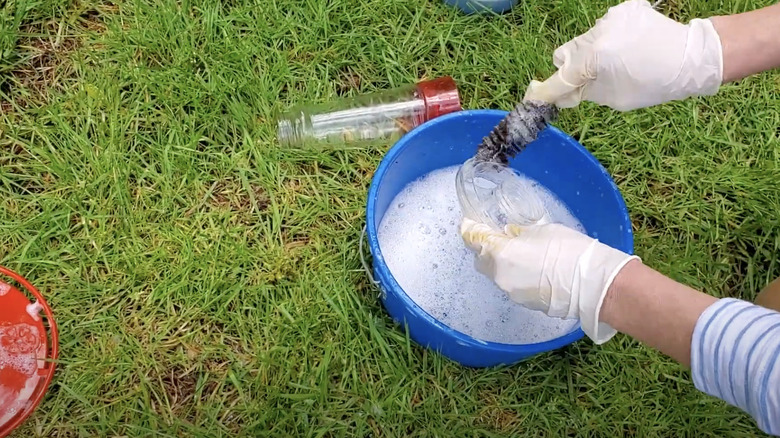 person cleaning hummingbird feeder