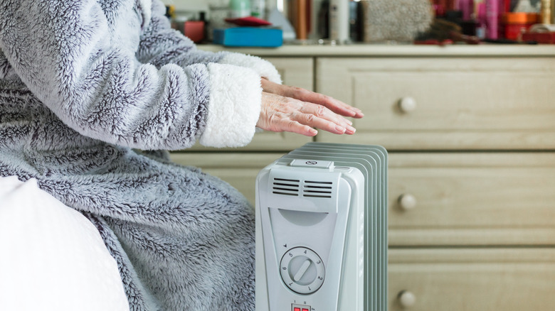 warming hands over space heater