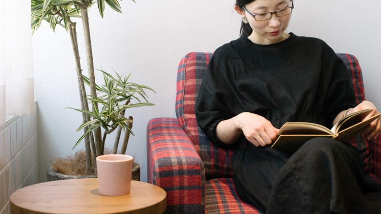 Woman reading in private, sunlit room