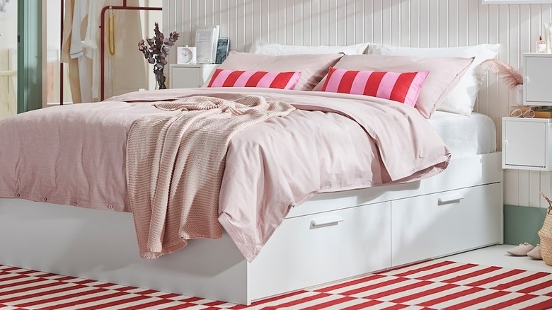 IKEA BRIMNES bed frame with pink and red bedware.