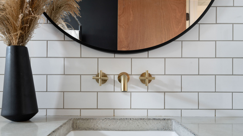 A close-up photo of a bathroom sink with brassware under a mirror