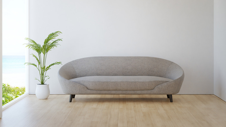 round gray couch with plant