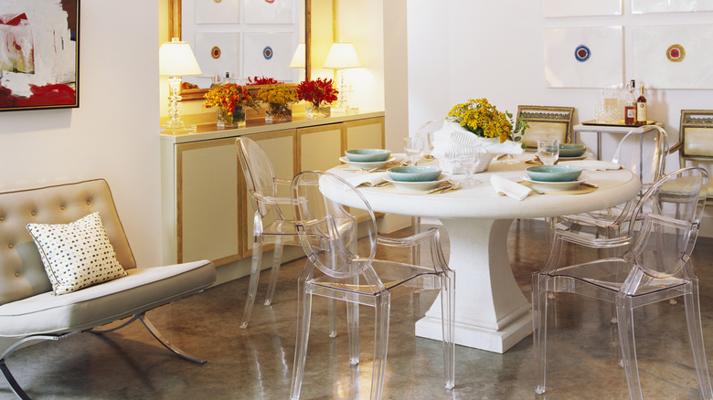 Acrylic chairs are placed around a dining table in a home