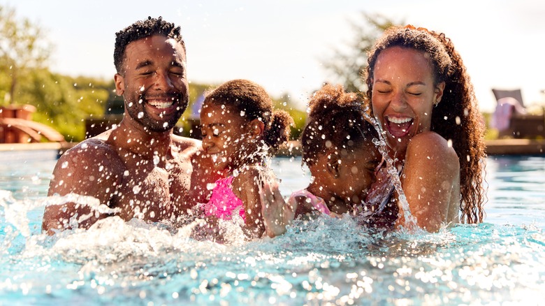 family playing in pool