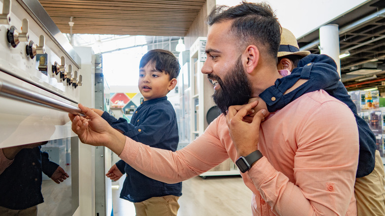 man examining stove in store