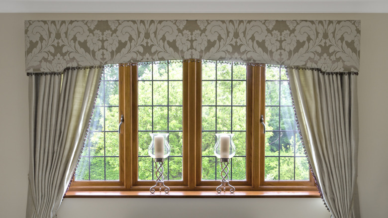 Valance over a window with stained wood trim and drapery