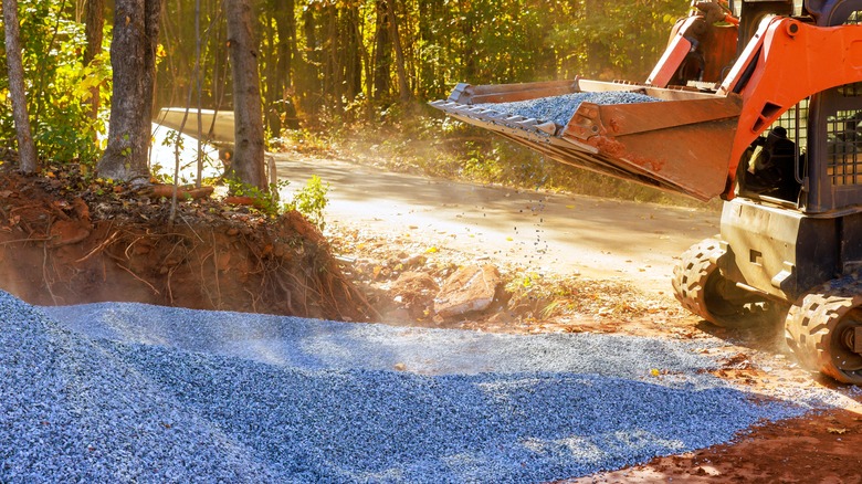 Crushed stone base being laid down for a new driveway or roadway