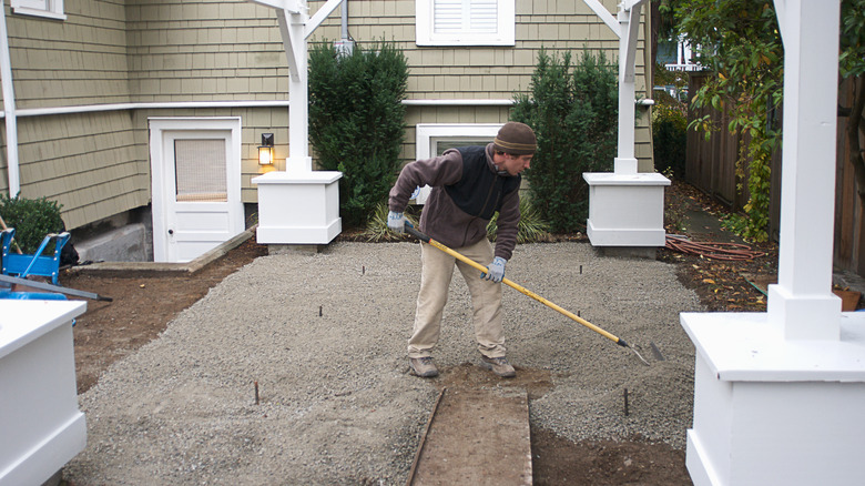 A worker shovels crushed stone