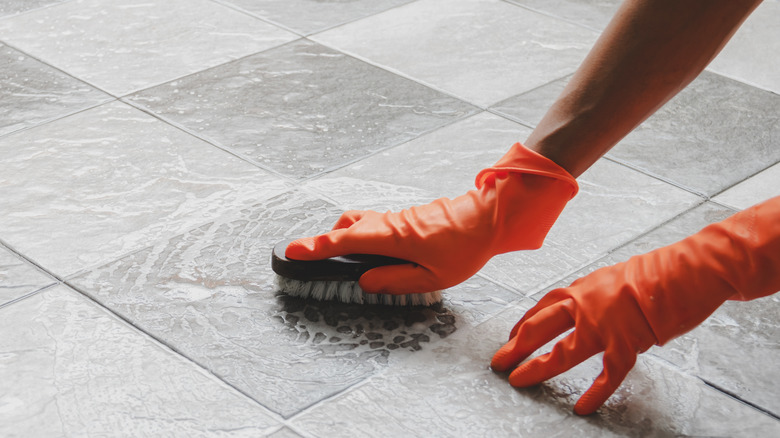 Hands scrubbing tile floor