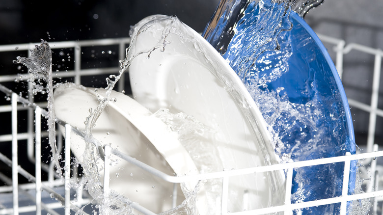 Dishes being sprayed with water inside a dishwasher