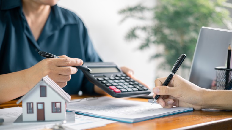 Mortgage broker showing numbers on a calculator