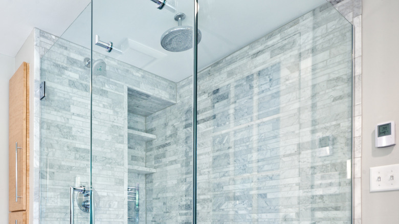 Man installs ceramic tile in shower