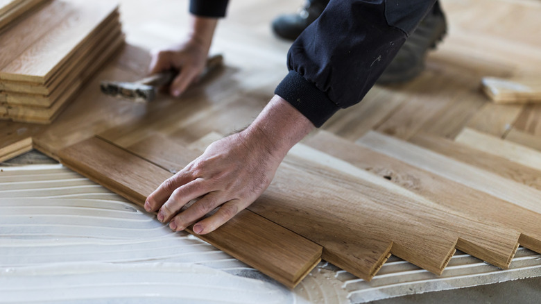 Person installing herringbone wood floor