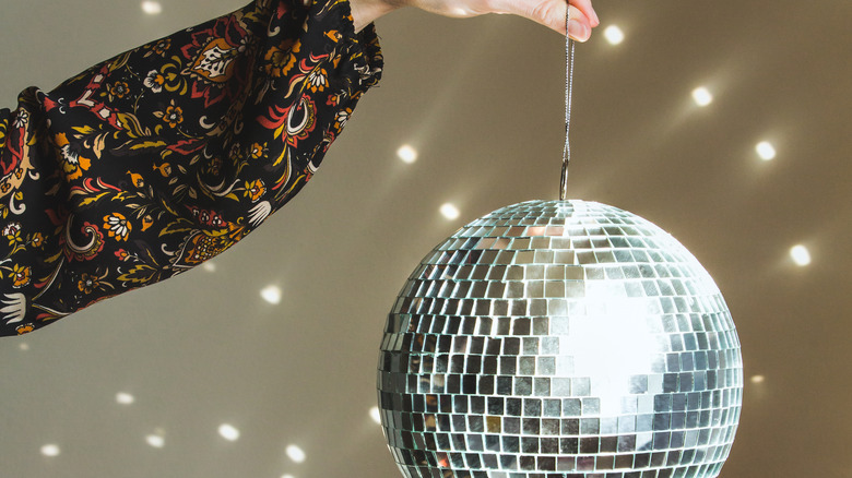 Person holding large disco ball