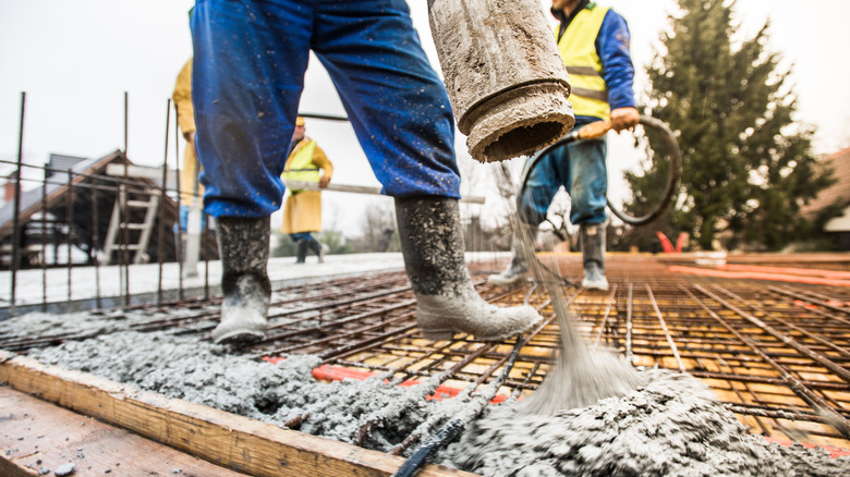 Construction worker pouring wet concrete