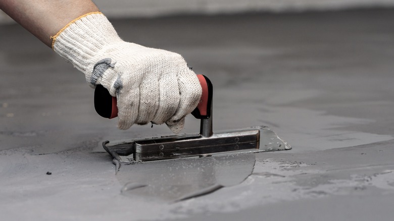 Person smoothing concrete with tool