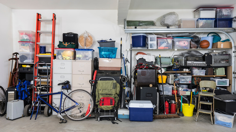 Disorganized garage with shelves and cabinets