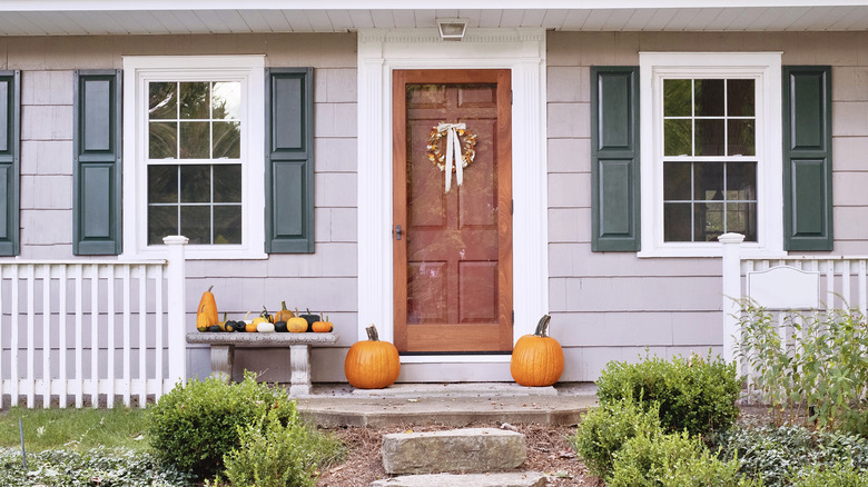 house exterior decorated for fall with pumpkins