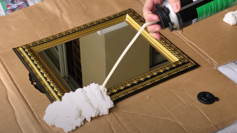 Applying spray foam on mirror