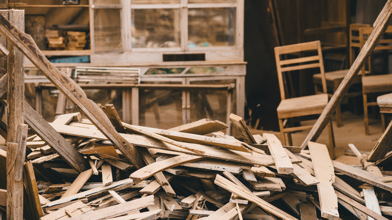 Disorganized pile of scrap wood in a workshop.