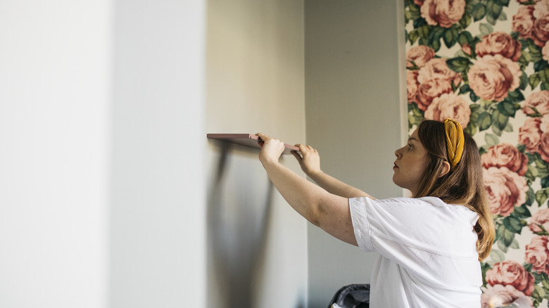 Woman preparing to mount shelves