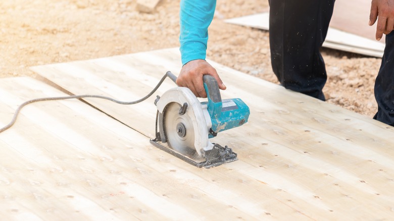 person cutting plywood