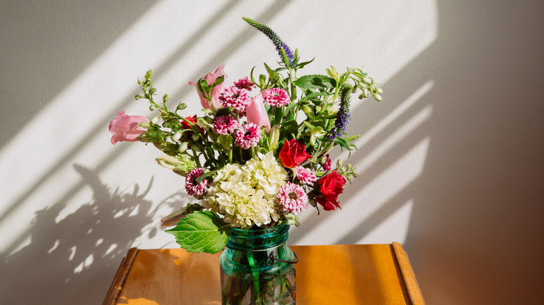 Old style jar full of flowers on a table