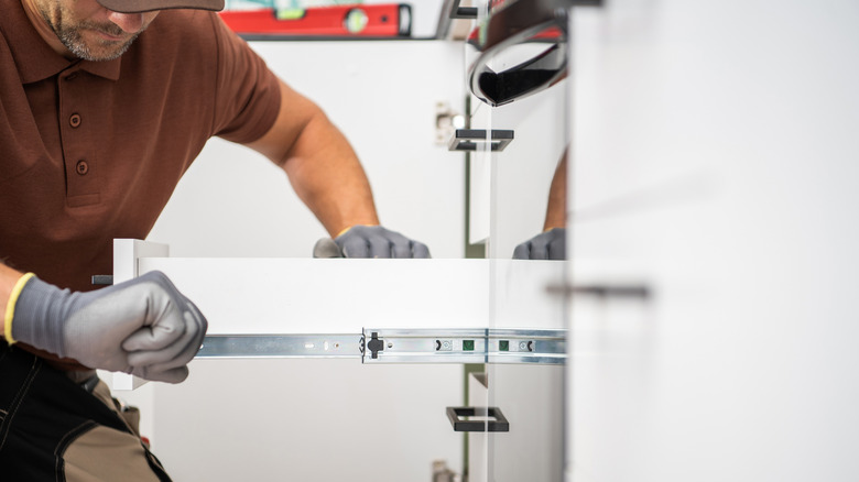 Person installing a drawer slide in the kitchen